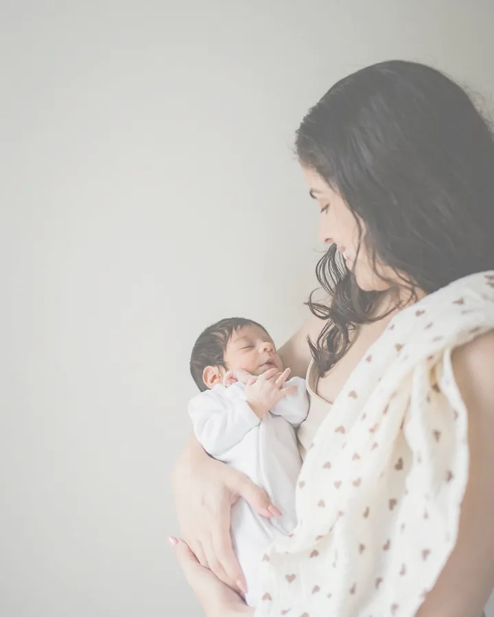 Sapir, attachment-based sleep consultant, holding her newborn daughter